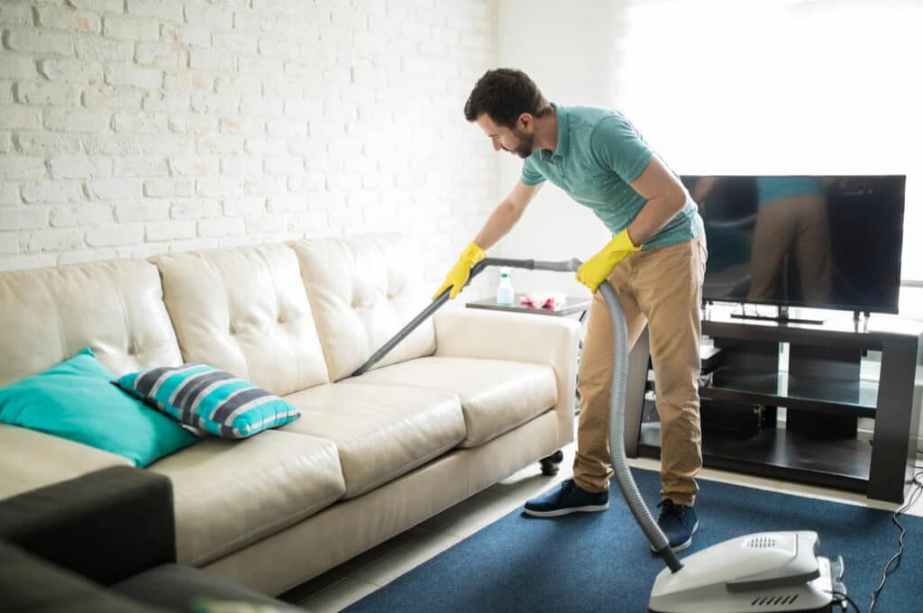 Fact or Fiction: 10,000 steps a day is better for your health 2 Man vacuuming/cleaning sofa