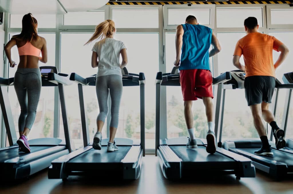 four-people-running-on-treadmills