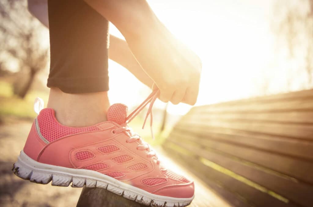 woman-tying-laces-of-red-running-shoes