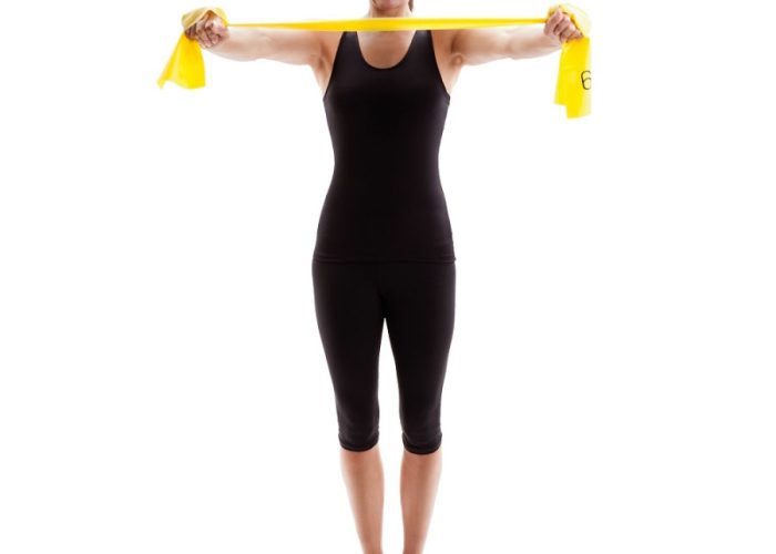 Woman Standing Upright with Yellow Exercise Bands Stretched in Front
